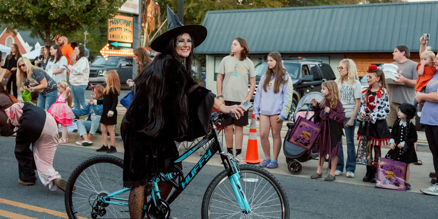 Woman dressed as a withc on bike